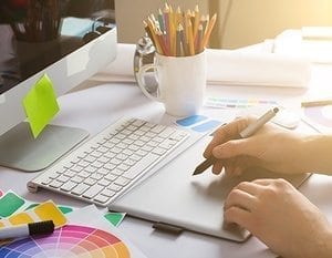 Young Handsome Graphic designer using graphics tablet to do his work at desk Young Handsome Graphic designer using graphics tablet to do his work at desk